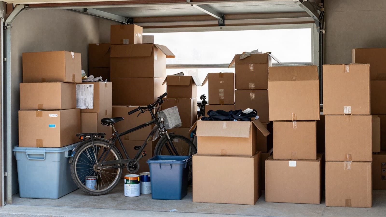 A residential garage packed with boxes, totes, and years of accumulated clutter.